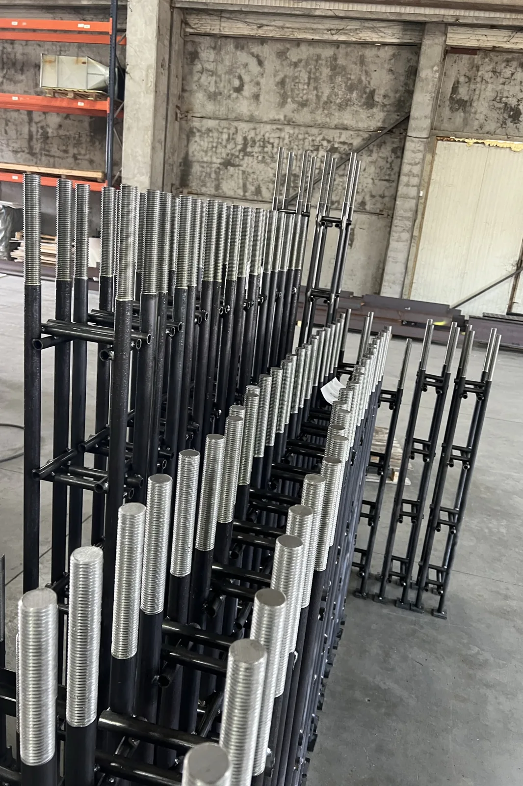 Batches of coated tube frames with threaded ends, staged for dispatch